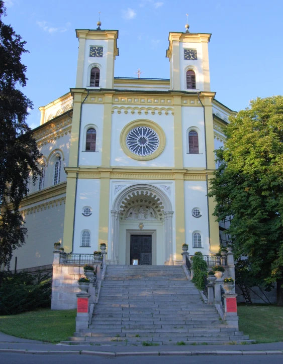 large yellow church with staircase leading to it