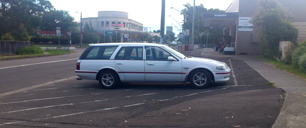 a white car sitting on the side of a road