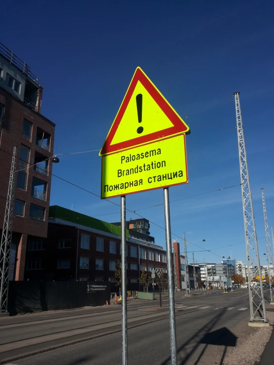 an upside down caution sign stands in front of a building on a street