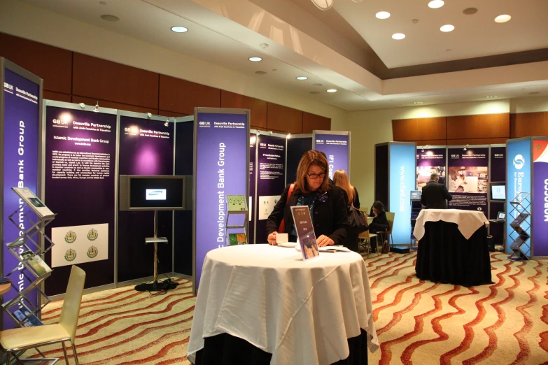 a person standing at a table in front of a display