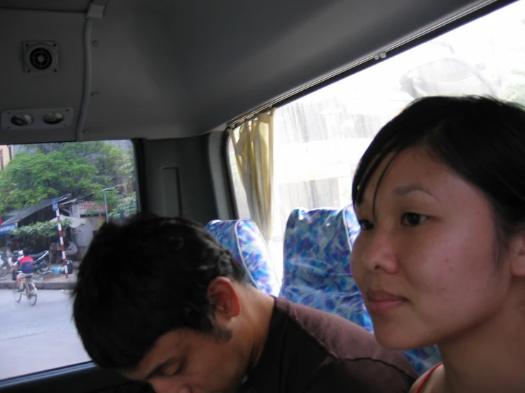 a woman sitting next to a man on a bus