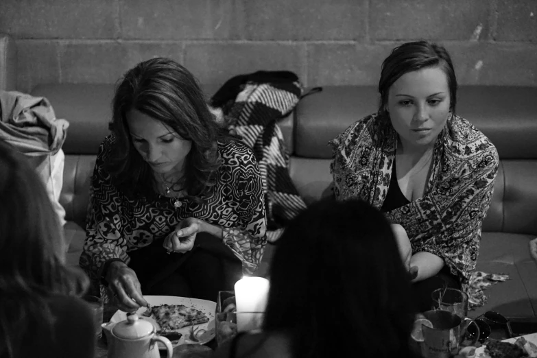 three women sit and eat at a dinner table