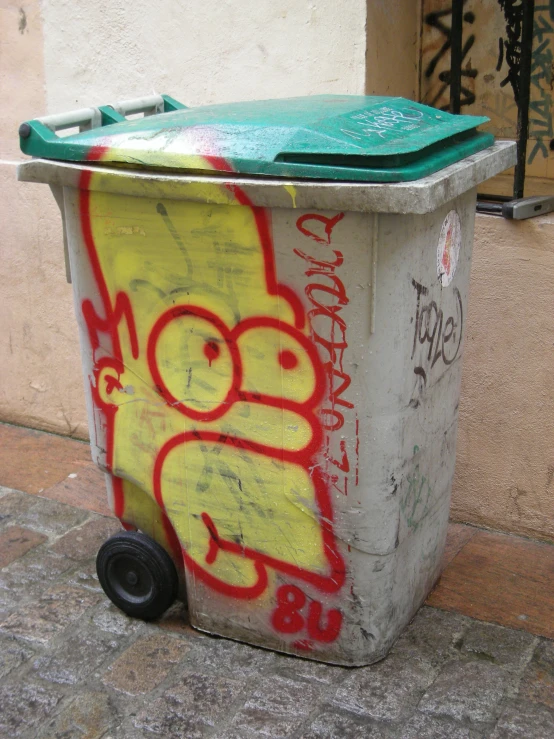 graffiti on a trash can on the side of the street