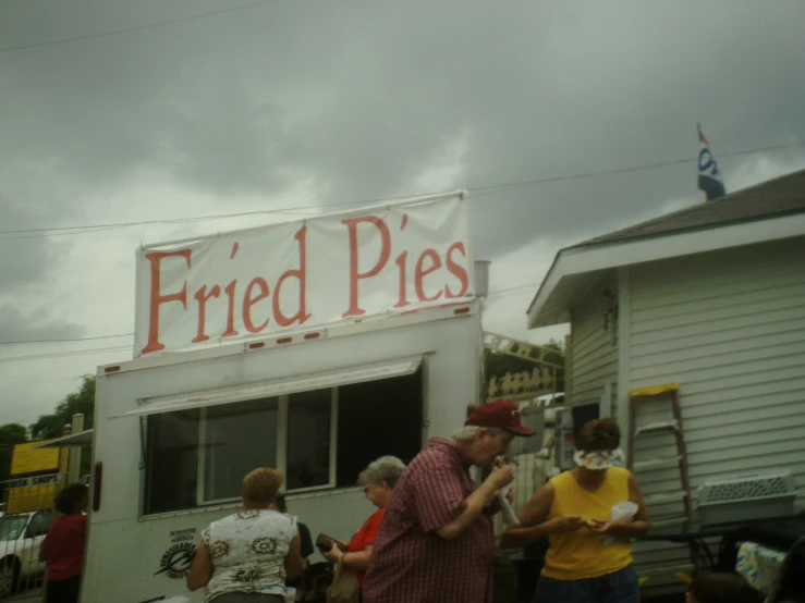 people standing around a truck in a front yard