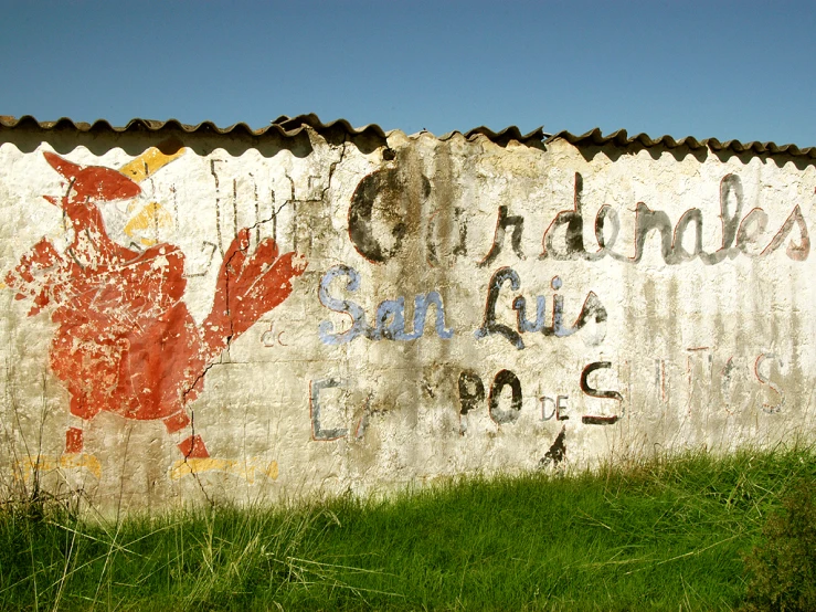 a fence painted with a sign and a red dragon on it