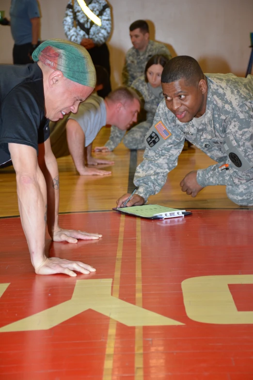 men in uniform practicing military stretching exercises on the floor