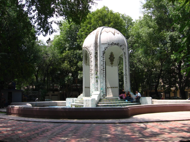 a fountain with a group of people sitting on the bench