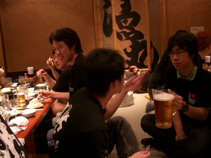 men at a table with beers and plates