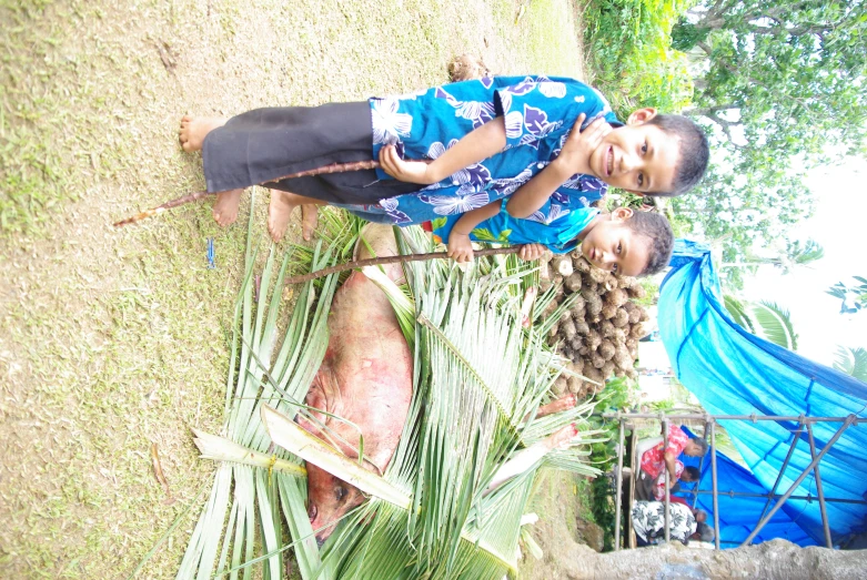 two s stand by a bush full of ripe fruit