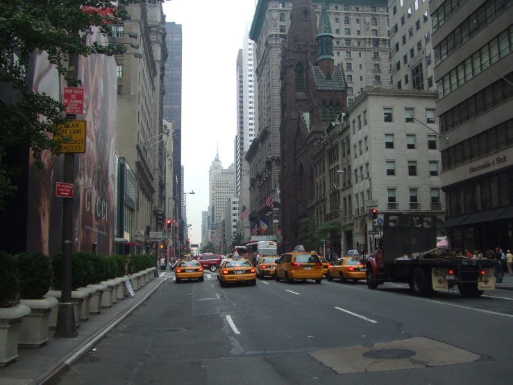 taxis in traffic on a city street lined with skyscrs