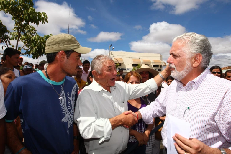 two men stand near each other while one of them holds his arm out