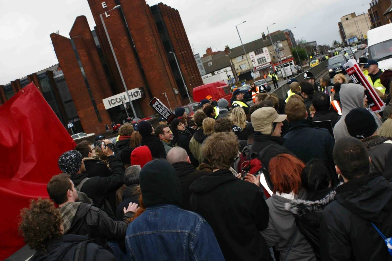 the crowd of people have gathered on the side walk