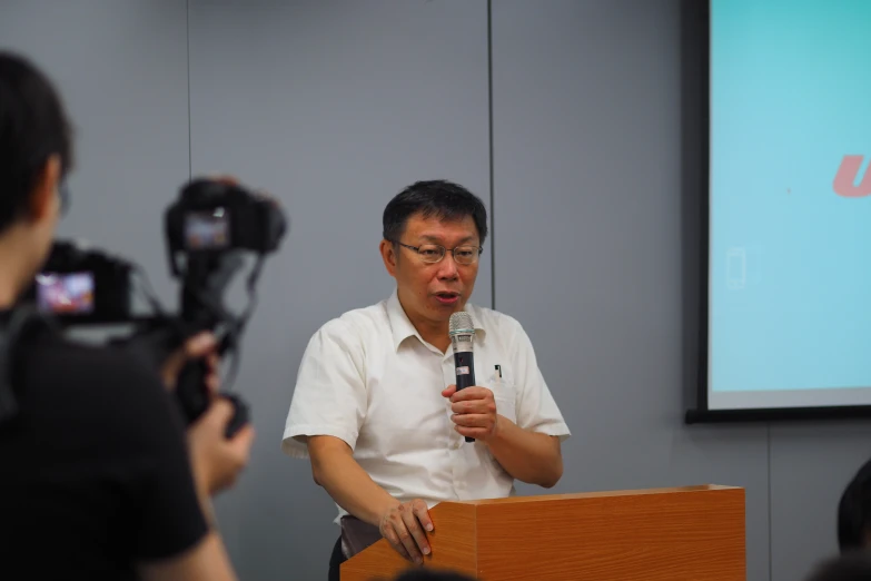 a man in white shirt holding a microphone