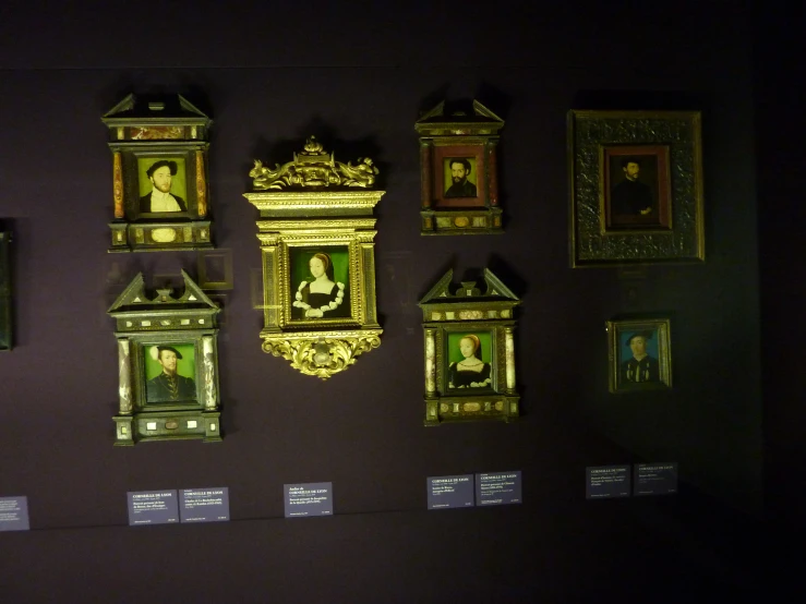 several gold framed paintings are hung on the wall