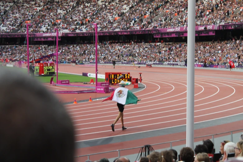 a female track runner in the middle of an olympic course