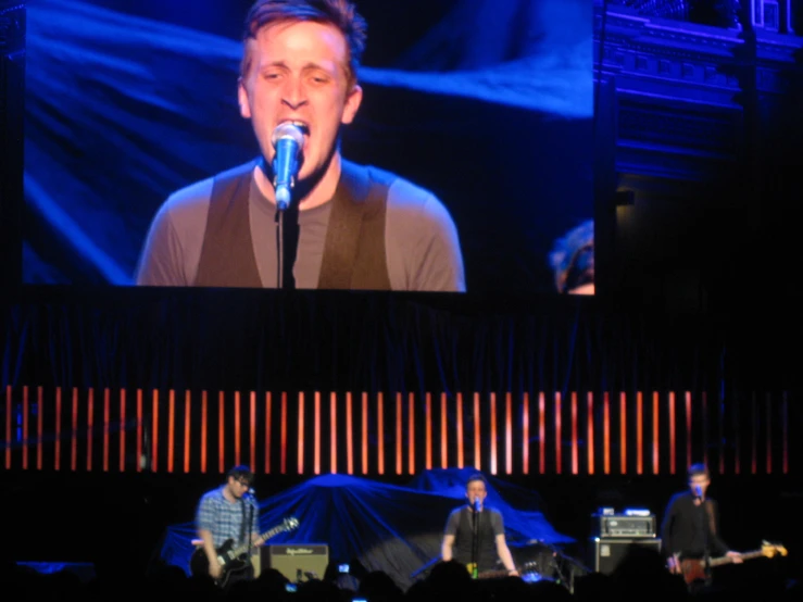 a man that is sitting in front of a microphone