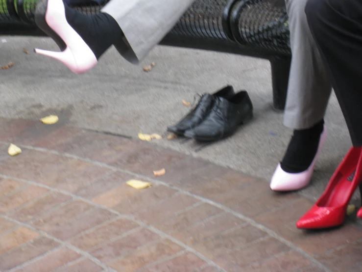 a pair of feet in heels sitting on a brick floor