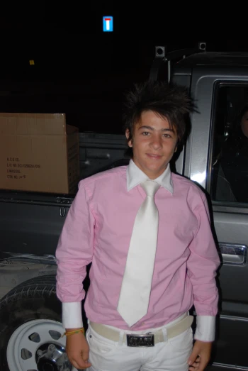 a young man dressed up with a pink shirt and white tie