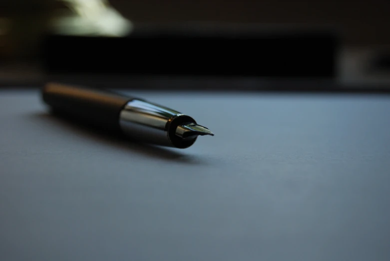 a pen on top of a white desk next to some metal devices