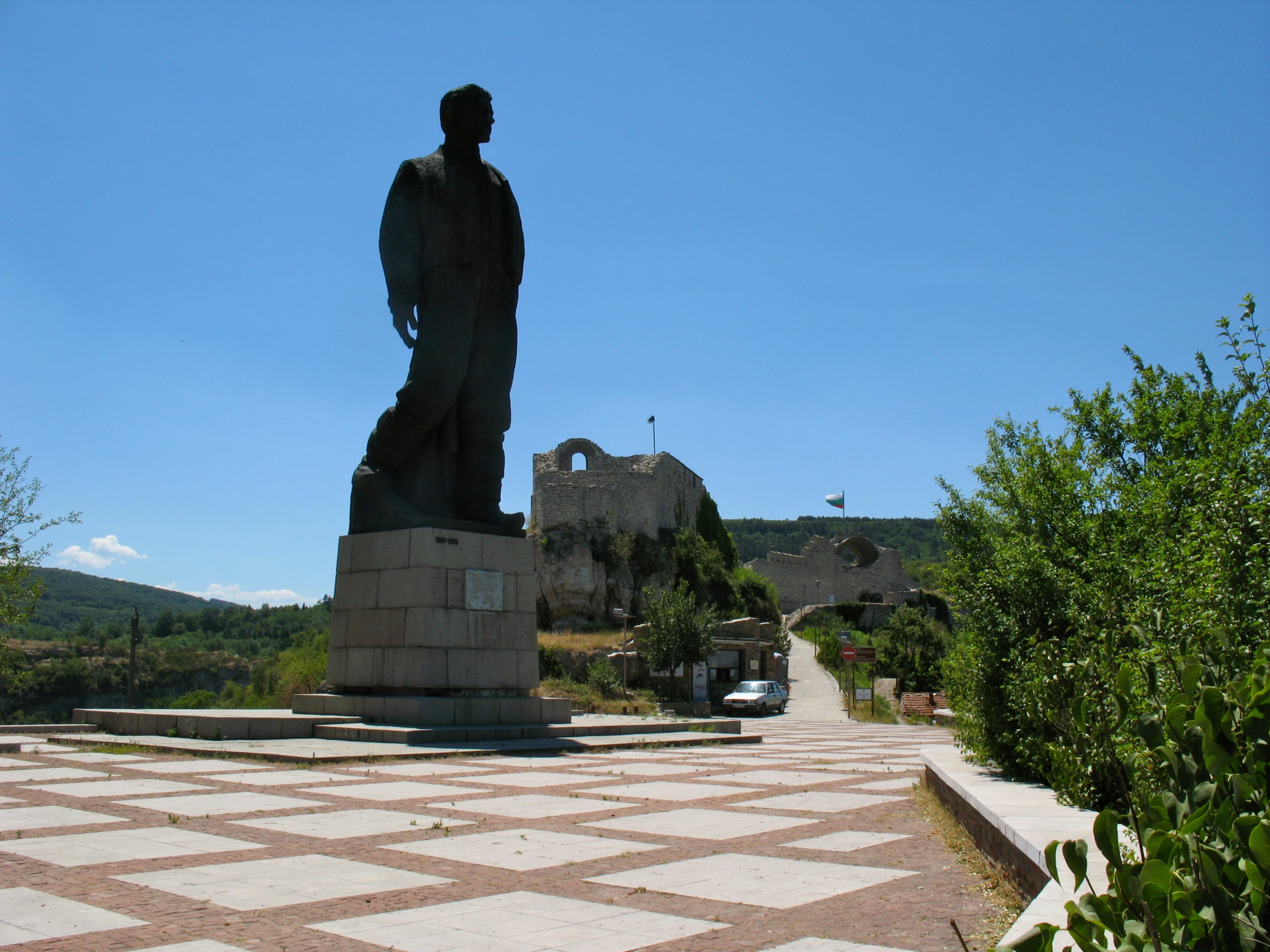 a statue in a park by a building