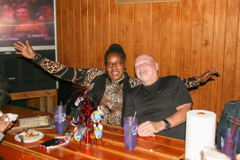 the man and woman are at a bar posing for a picture