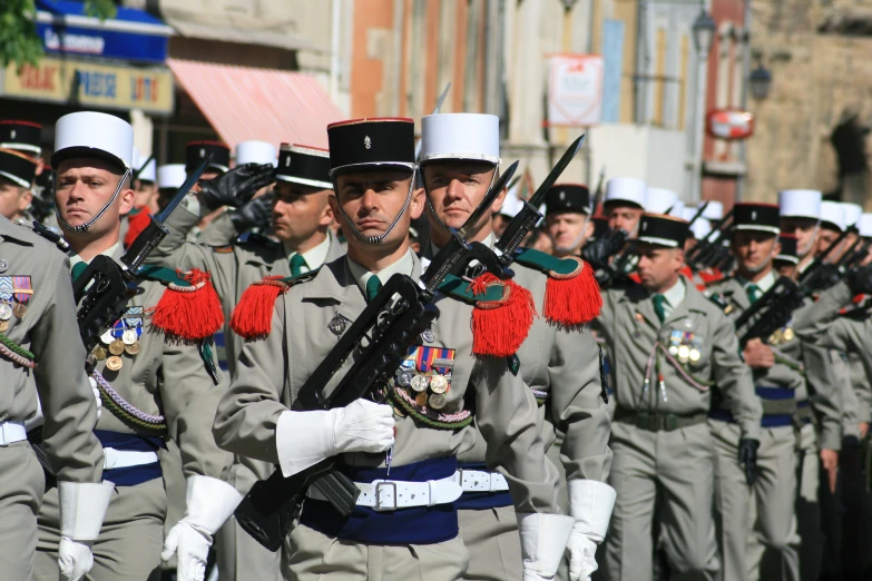 a group of men in dress uniforms standing on a street