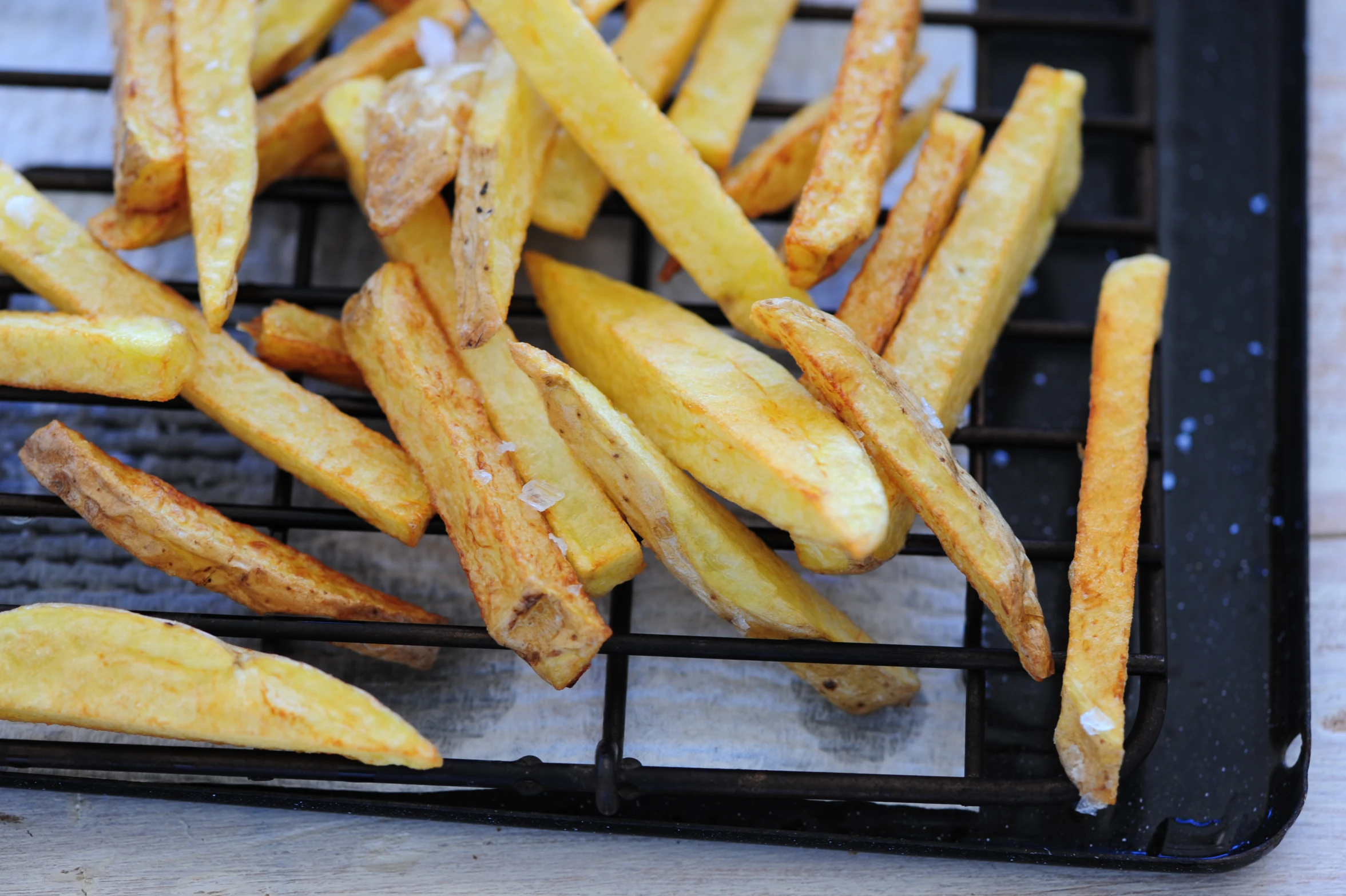 several small french fries sitting on a grill