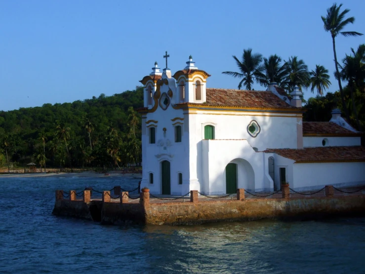 a building on the water near many trees