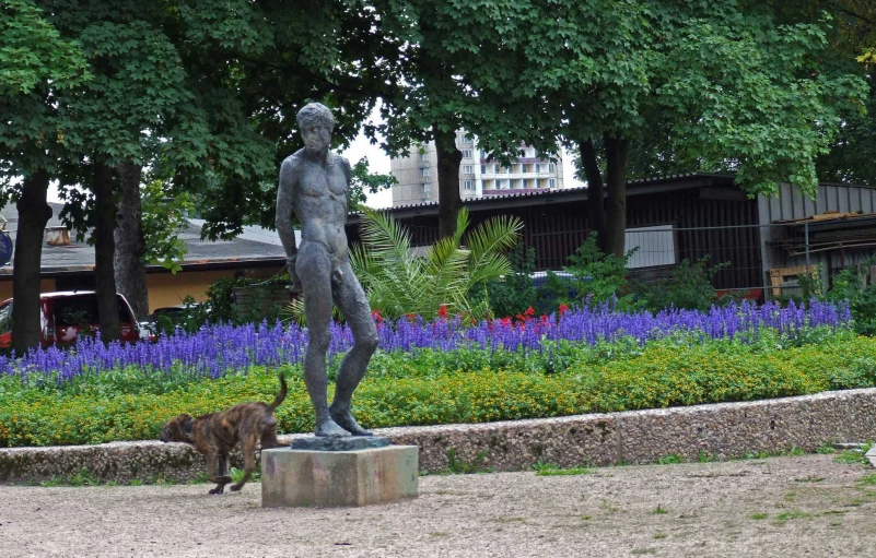 a statue that has some flowers around it