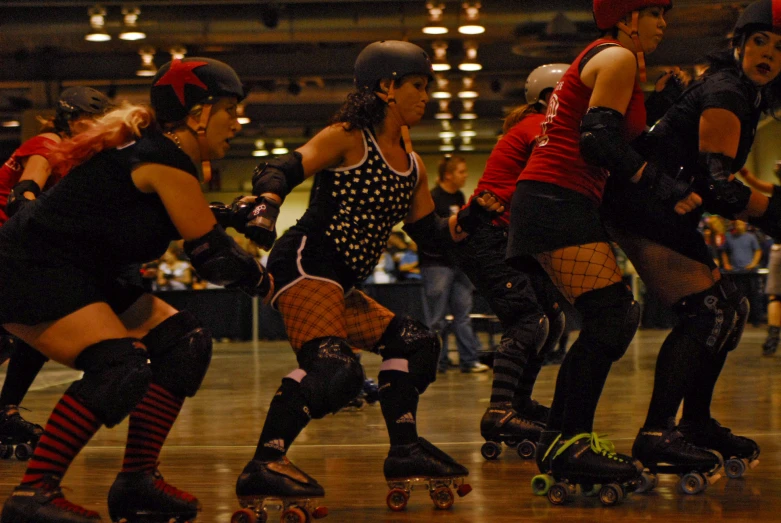 several people wearing body guards and knee pads are skate boarding together