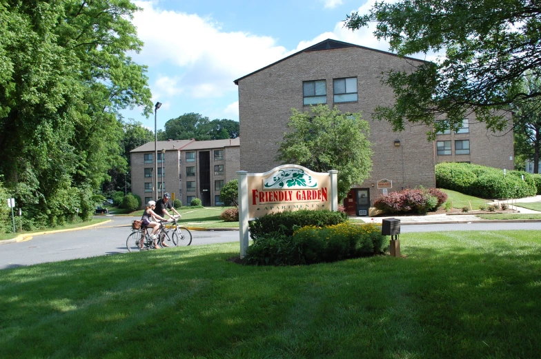 a man riding his bike past a sign that reads coffeehouse