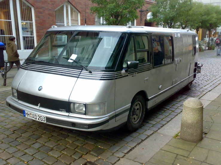 a silver van parked on top of a brick road