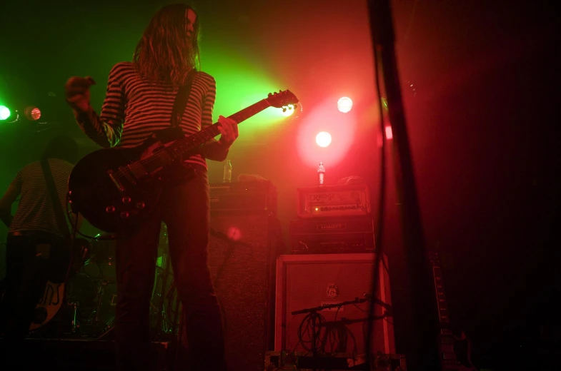 a band performs on stage in front of brightly lit lights