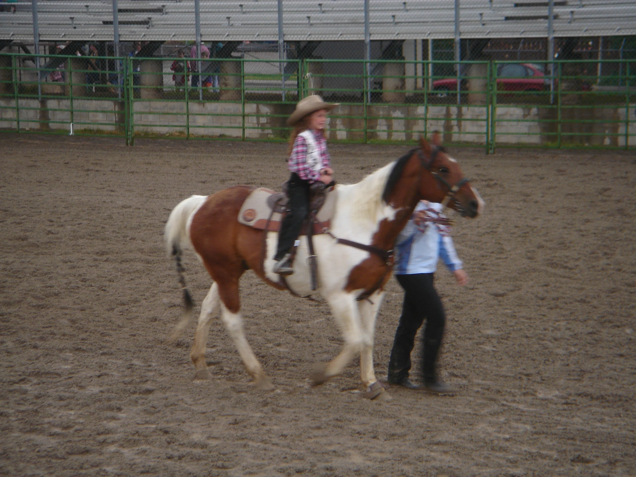 two women, each on one horse, are talking while on the other is standing