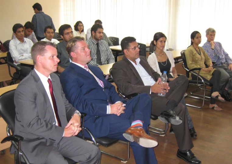 several people are sitting in chairs watching an audience