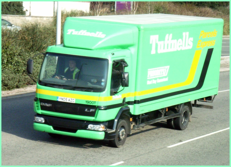 a large green truck driving down the road