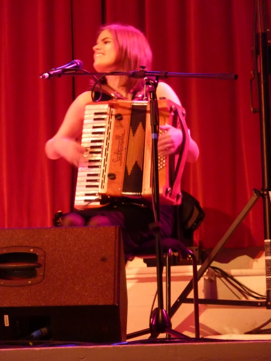 the woman is playing the accordion on the stage