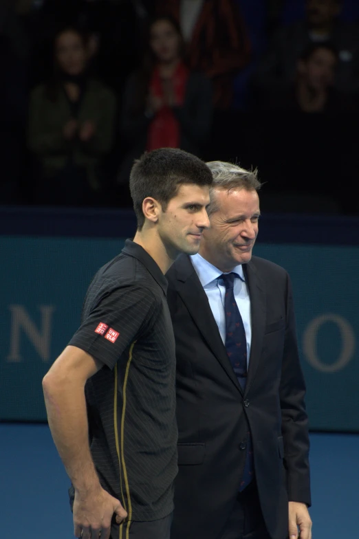 two men standing next to each other in front of a crowd