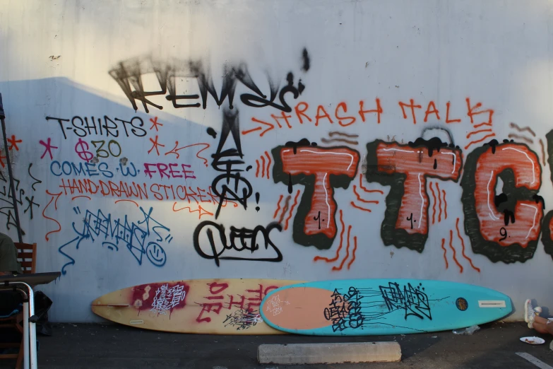 a surfboard in front of graffiti covered wall