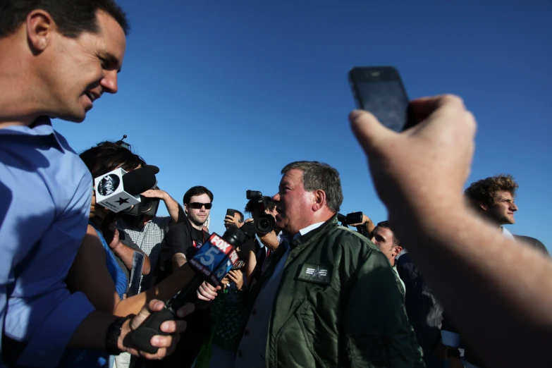 two men with cameras and some reporters