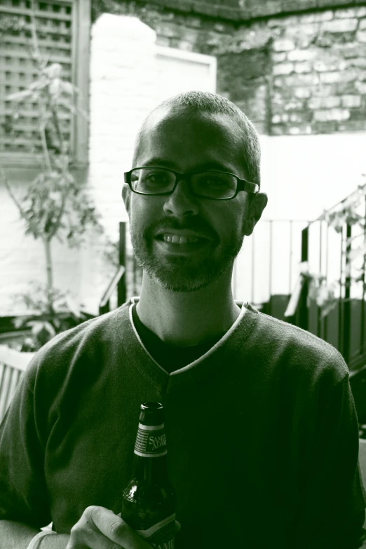 a man holding a beer while sitting down