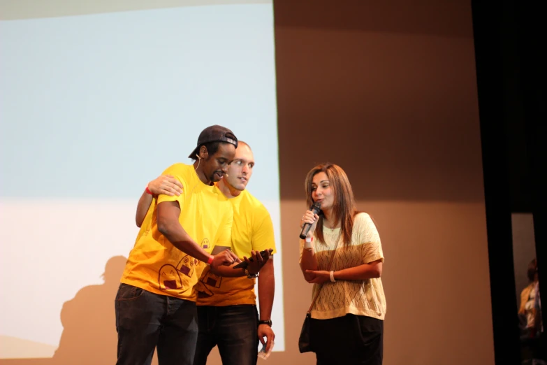 two people in front of a screen on a stage