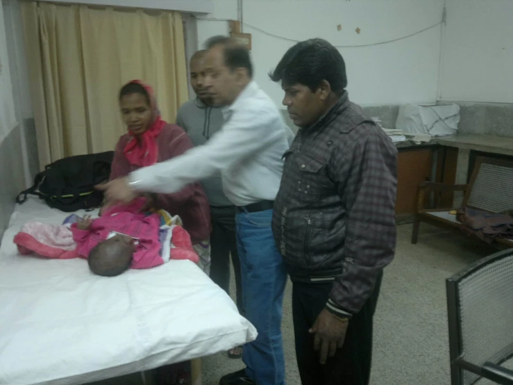 a group of people stand in a hospital room