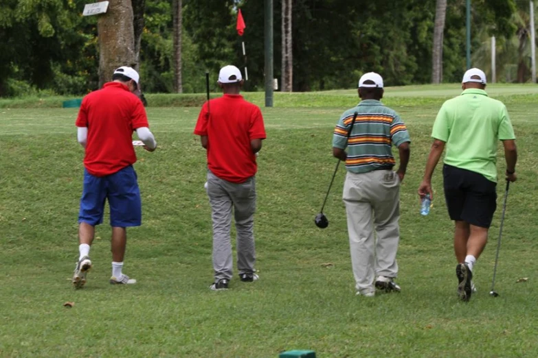 several men playing golf on a grassy field
