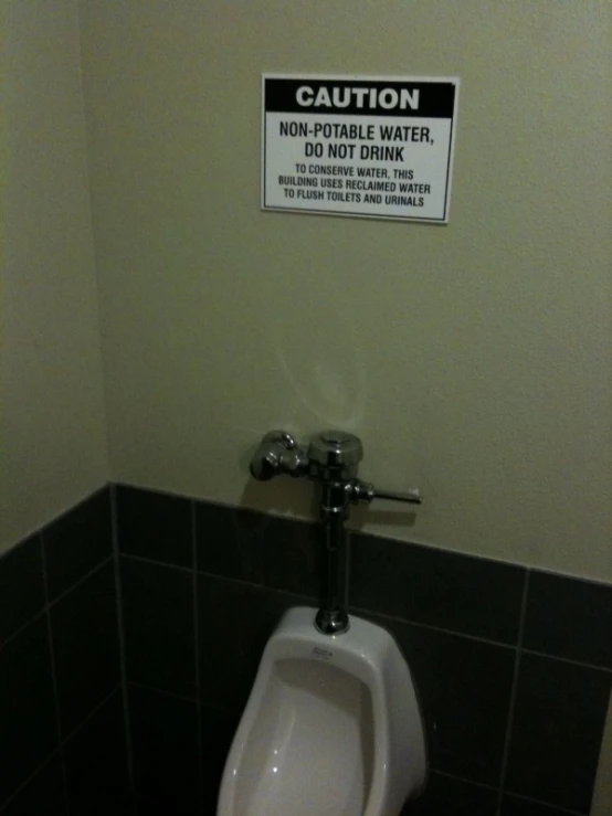 an overhead water closet with a sign saying caution