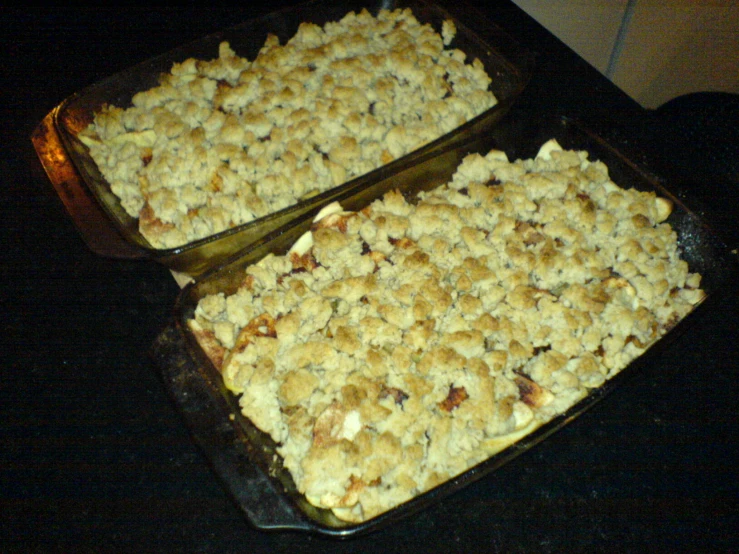 two pans are full of food with topping