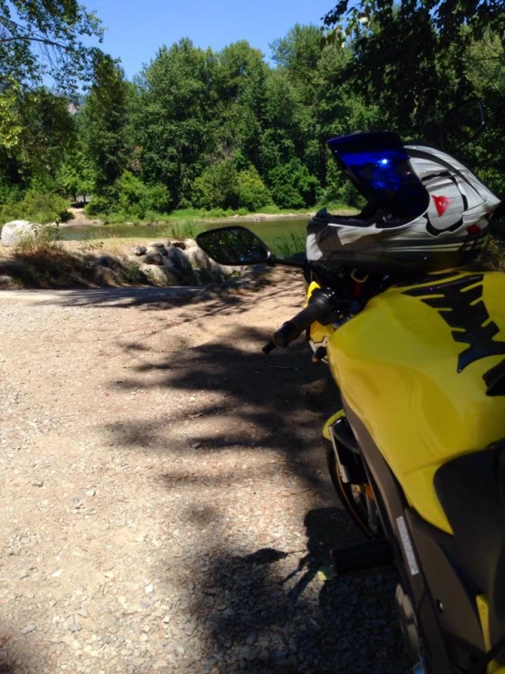 a motorcycle sits on gravel and under trees