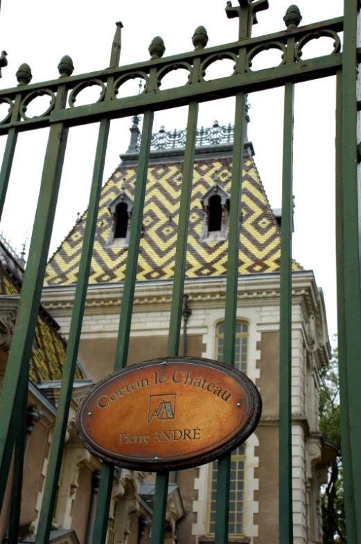 a building through the fence and a sign behind it