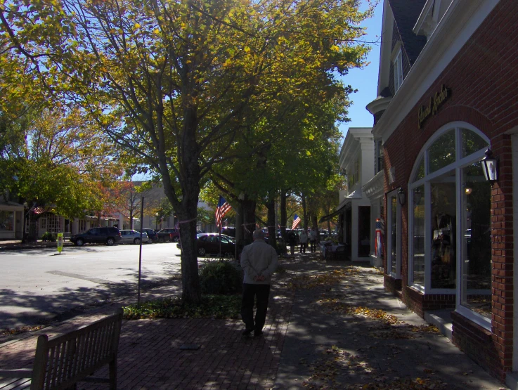 a woman walking down the street in the fall time