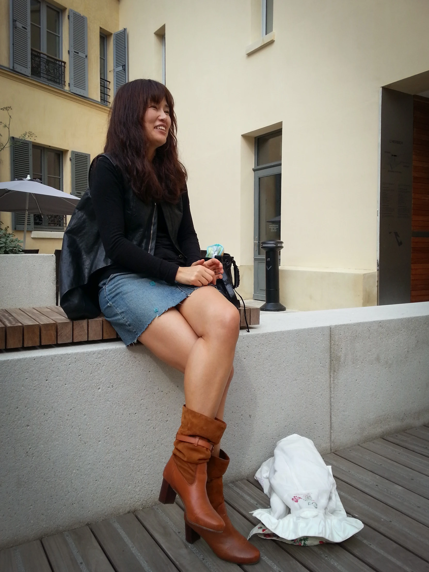 a woman with short legs sits on a ledge